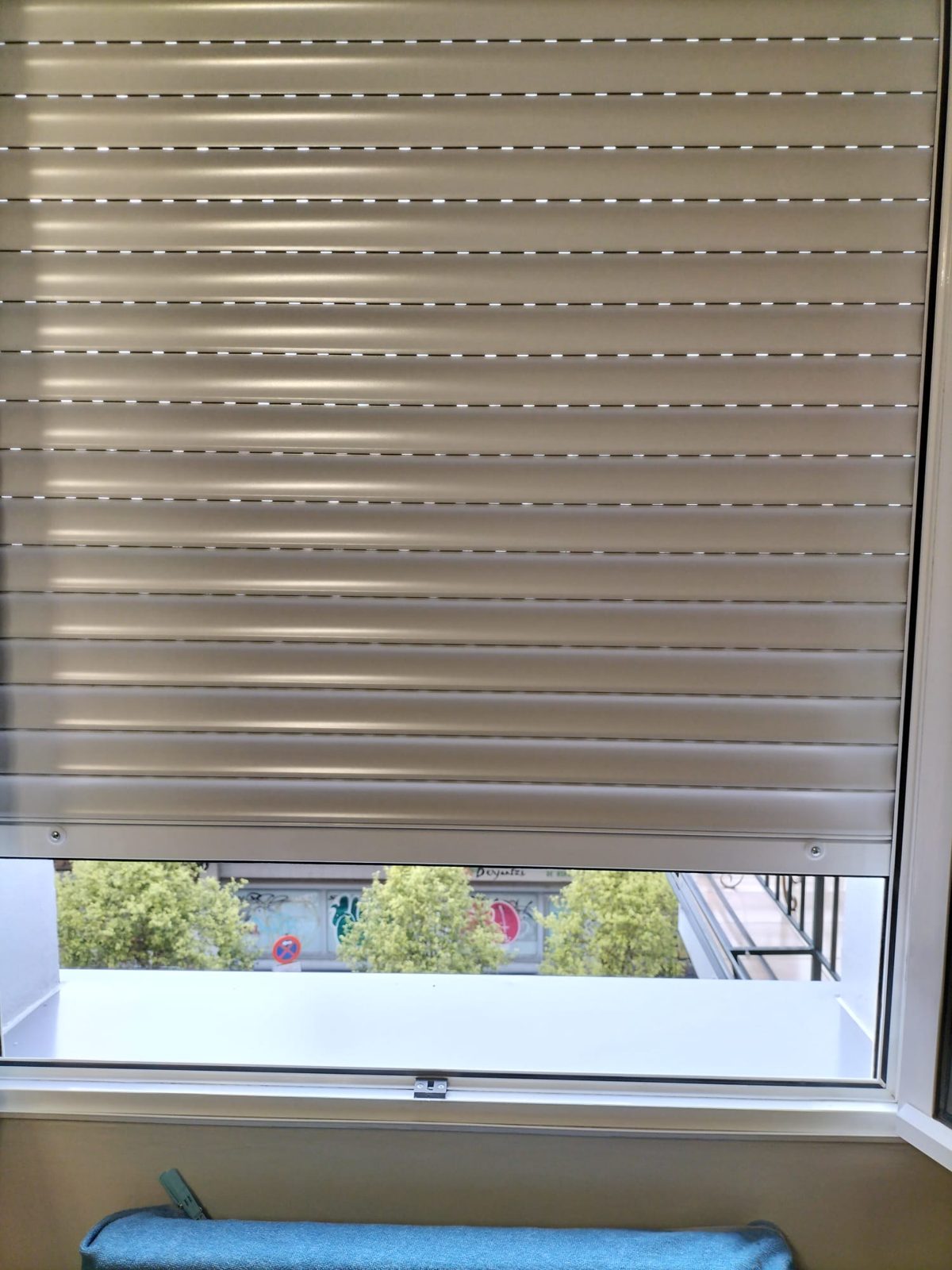 Persiana de aluminio color champán bajada casi por completo